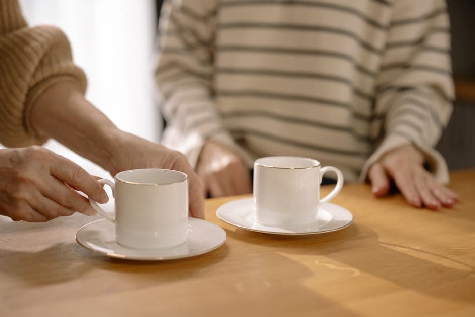 Two cups of coffee on a wooden table during a quiet conversation